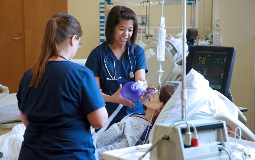 Nursing students practice giving oxygen to a dummy.